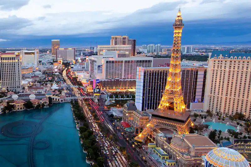 Toàn cảnh Las Vegas lúc chạng vạng với tháp Eiffel phiên bản thu nhỏ sáng đèn và đại lộ đông xe
