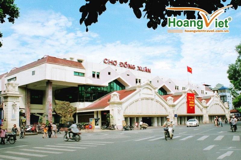 Mặt tiền chợ Đồng Xuân với dòng xe máy qua lại trên đường phố Hà Nội