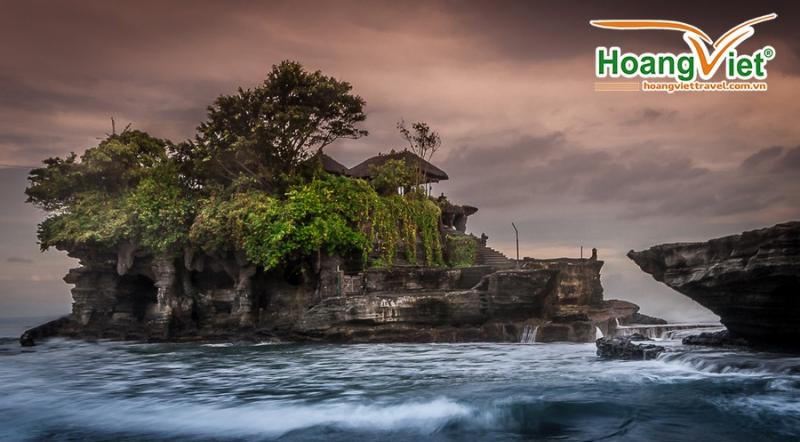 Ngôi đền Tanah Lot nằm trên mỏm đá giữa biển với sóng vỗ lúc hoàng hôn