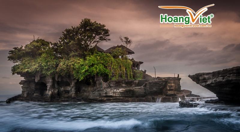 Ngôi đền Tanah Lot nằm trên mỏm đá giữa biển với sóng vỗ lúc hoàng hôn