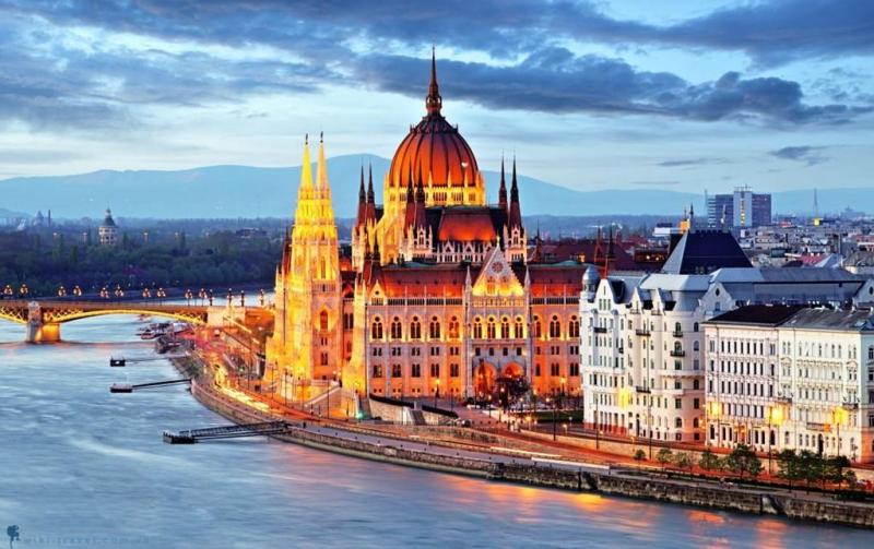 Tòa nhà Quốc hội Hungary lên đèn vàng bên bờ sông Danube lúc chiều tối