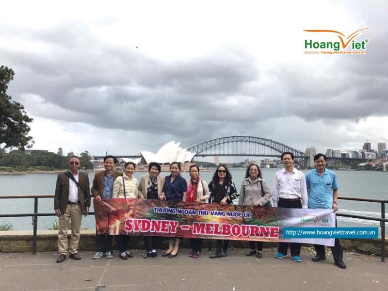 Đoàn khách chụp ảnh với Nhà hát Con Sò và cầu cảng Sydney phía sau