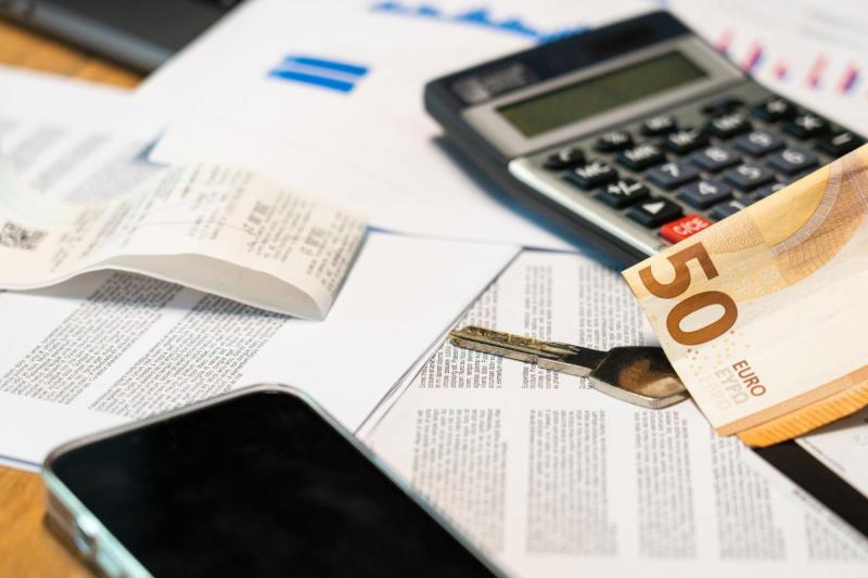 Tờ 50 euro, máy tính và giấy tờ minh họa chứng minh tài chính.