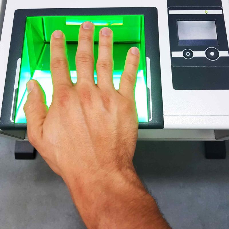Bàn tay đặt trên thiết bị quét vân tay sinh trắc học khi làm thủ tục visa.