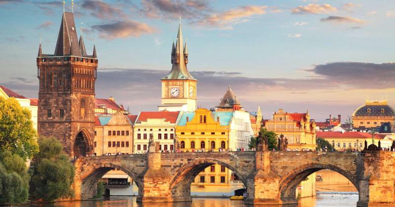 Cầu Charles cùng tháp đồng hồ và các tòa nhà đủ màu bên sông ở Praha