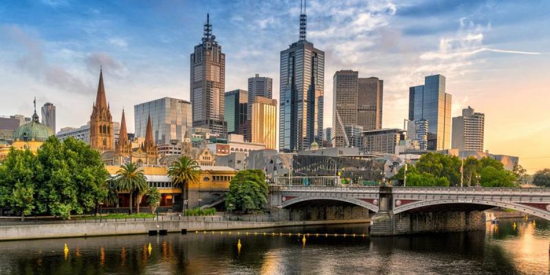 Các tòa nhà chọc trời và nhà thờ cổ của Melbourne soi bóng xuống dòng sông lúc hoàng hôn