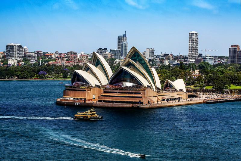 Nhà hát Opera Sydney với một chiếc phà vàng chạy trên mặt nước xanh