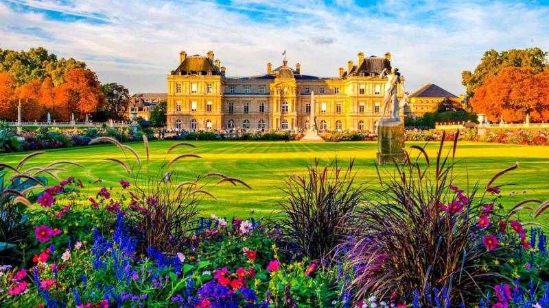 Cung điện Luxembourg phía sau thảm cỏ và vườn hoa rực rỡ sắc màu