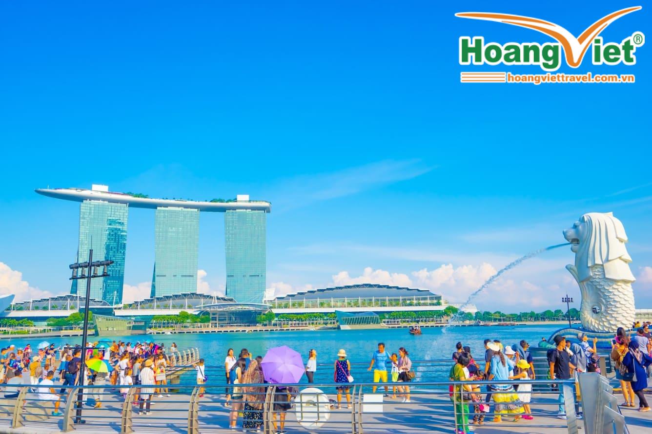 Tượng Merlion phun nước với tòa nhà Marina Bay Sands ở phía sau. Dòng người du lịch dưới bầu trời xanh trong vắt càng làm tăng thêm sức sống cho đường chân trời Singapore.