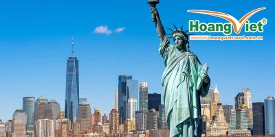 Tour Mỹ liên tuyến Đông Tây Tượng Nữ thần Tự do sừng sững nổi bật trên nền trời xanh trong vắt, phía sau là đường chân trời của thành phố New York, bao gồm cả tòa nhà One World Trade Center.