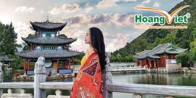 Tour Côn Minh - Đại Lý - Lệ Giang - Shangrila Từ Hà Nội 6n5đ Cô gái khoác khăn họa tiết đỏ đứng bên cầu đá trước lầu Đắc Nguyệt ở hồ Hắc Long Đầm Lệ Giang