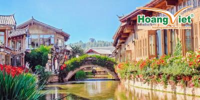 Ảnh Lệ Giang Cổ Trấn - Trung Hoa. Tour Đại Lý - Lệ Giang - Shangrila Kiến trúc truyền thống Trung Hoa nằm dọc theo một con kênh yên tĩnh, được tô điểm bởi những bông hoa và cây xanh rực rỡ. Một cây cầu đá uốn cong duyên dáng ở giữa.