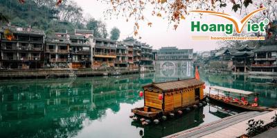 Tour Trương Gia Giới - Phượng Hoàng Cổ Trấn từ Hà Nội Những chiếc thuyền gỗ truyền thống nhẹ nhàng trôi trên dòng sông xanh ngọc êm đềm, hai bên là những công trình kiến trúc cổ kính của Trung Hoa. Lá mùa thu rụng xuống càng làm tăng thêm vẻ thanh bình.