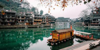 Tour Trương Gia Giới - Phượng Hoàng Cổ Trấn từ Hà Nội Những chiếc thuyền gỗ truyền thống nhẹ nhàng trôi trên dòng sông xanh ngọc êm đềm, hai bên là những công trình kiến trúc cổ kính của Trung Hoa. Lá mùa thu rụng xuống càng làm tăng thêm vẻ thanh bình.