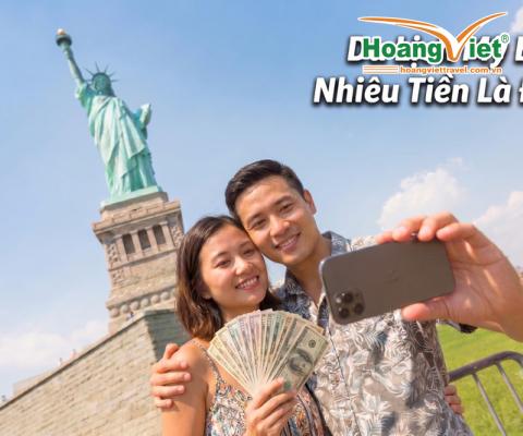 Một cặp đôi tươi cười chụp ảnh tựa sướng trước Tượng Nữ thần Tự do. Người phụ nữ cầm một xấp tiền. Bầu trời trong xanh, báo hiệu một ngày ấm áp và vui vẻ.