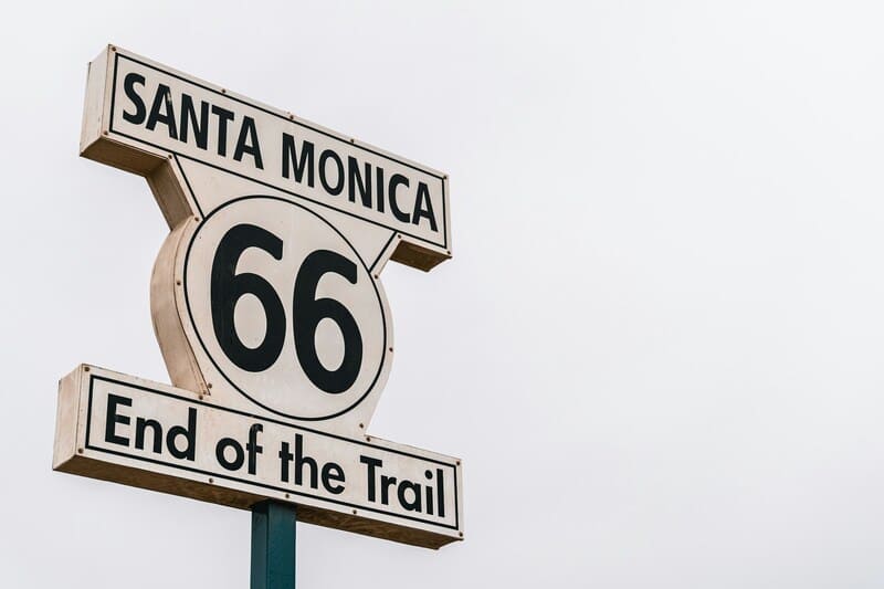 Biển báo Santa Monica 66 End of the Trail màu trắng chữ đen trên nền trời sáng