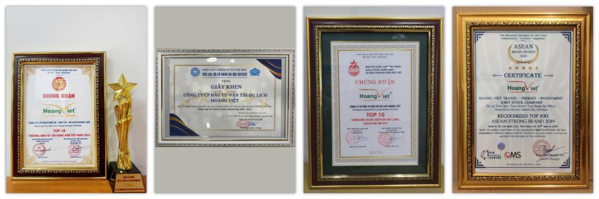Bốn bằng khen được đóng khung và một chiếc cúp vàng được trưng bày. Mỗi bằng khen đều có văn bản và biểu tượng chi tiết, thể hiện sự công nhận và thành tích. Không khí trang trọng và hân hoan.