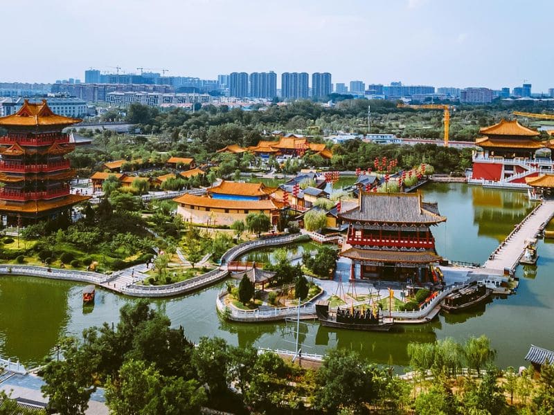 Ảnh chụp từ trên cao một khu vườn Trung Quốc thanh bình với những ngôi chùa truyền thống và những con đường uốn lượn quanh những ao hồ tĩnh lặng. Cây xanh tươi tốt bao quanh kiến trúc sống động.