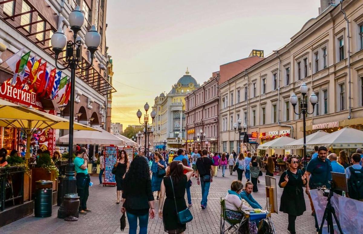 Phố đi bộ Arbat đông đúc, hai bên là hàng quán và các tòa nhà kiến trúc cổ điển dưới ánh hoàng hôn