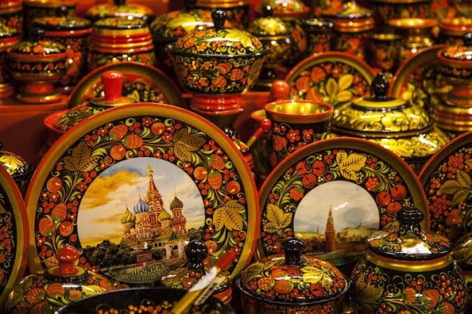 Đồ sơn mài Nga được trang trí công phu, thể hiện những họa tiết hoa rực rỡ và các địa danh nổi tiếng. Khung cảnh gợi lên cảm giác về di sản văn hóa phong phú.