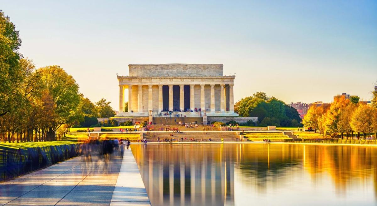 Đài tưởng niệm Abraham Lincoln tại National Mall vào mùa thu với hồ Reflecting Pool và hàng cây lá vàng phản chiếu trên mặt nước.