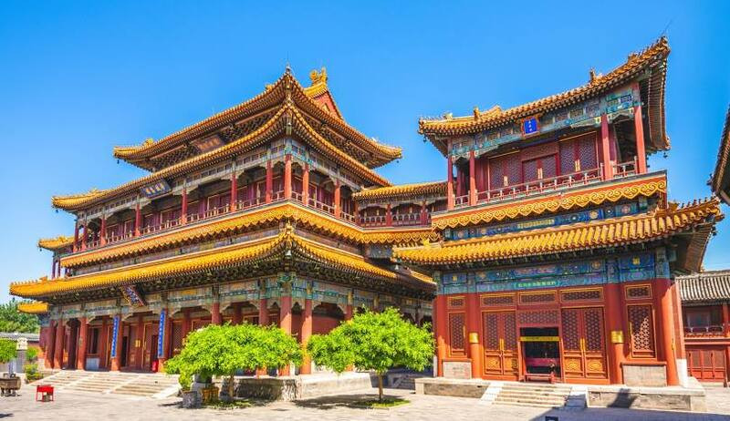 Chùa Ung Hòa ở Bắc Kinh với kiến trúc mái ngói vàng, cột đỏ và hai cây xanh phía trước dưới trời xanh