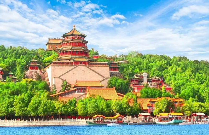 Tháp Phật Hương ở Di Hòa Viên trên đồi cây xanh, bên hồ Côn Minh với các thuyền du lịch neo đậu gần bờ