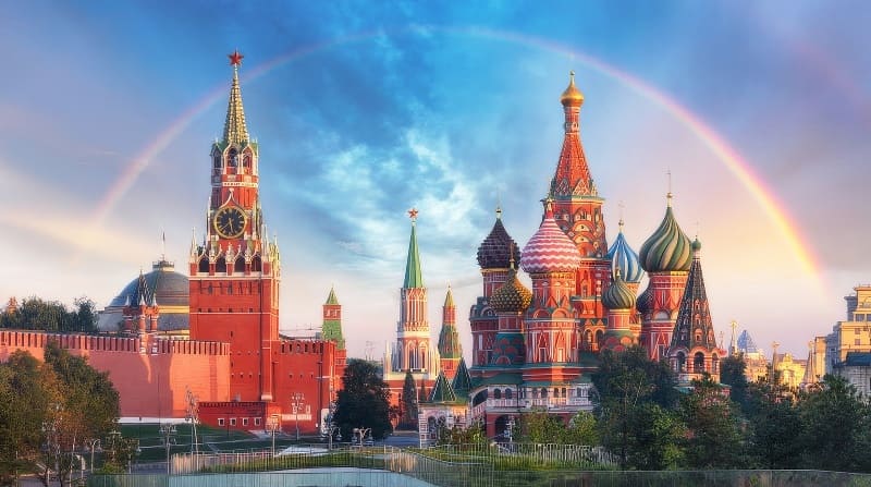 Thánh đường Saint Basil và tháp Spasskaya Điện Kremlin ở Moscow dưới bầu trời xanh có cầu vồng