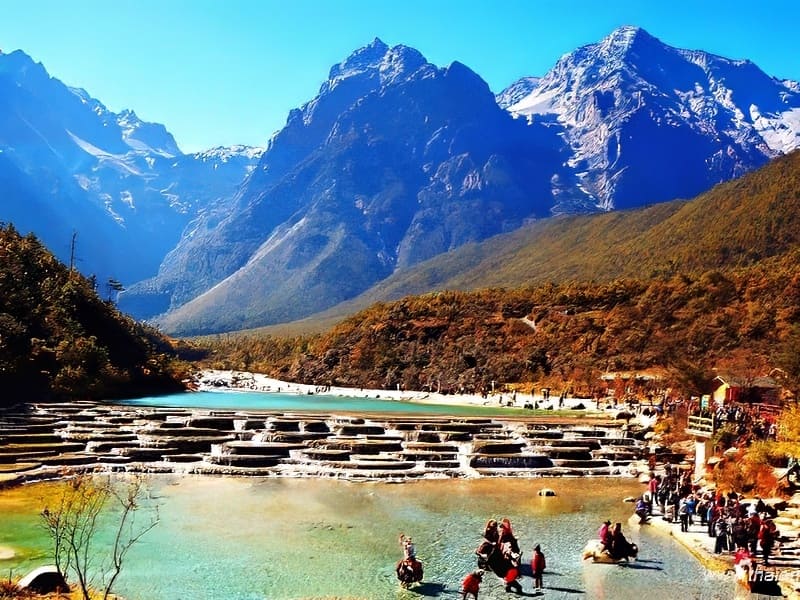 Khung cảnh ngoạn mục của Thung lũng Trăng Xanh với những dòng nước màu ngọc lam chảy xiết và những ngọn núi phủ tuyết trắng hùng vĩ ở phía xa. Du khách thích thú với phong cảnh sống động này.
