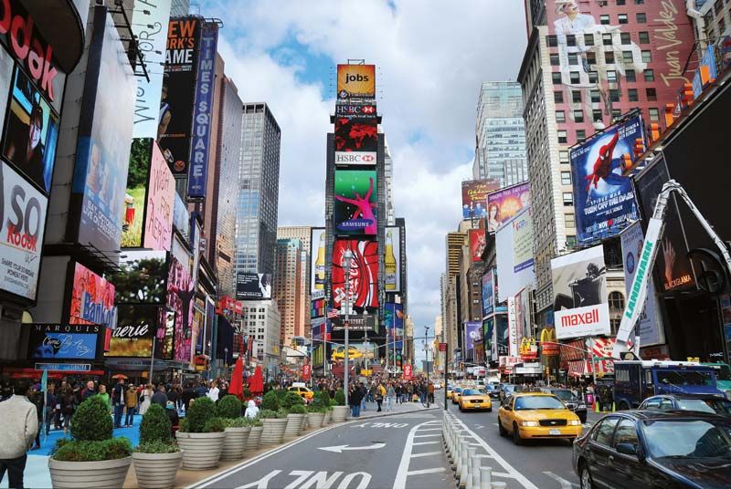 Quảng trường Times Square nhộn nhịp ở thành phố New York, tràn ngập những biển quảng cáo rực rỡ, đám đông người qua lại và những chiếc taxi màu vàng. Một khung cảnh đô thị sống động và đầy màu sắc.