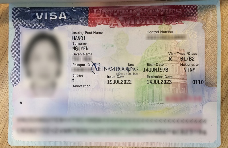 Visa Mỹ với ảnh và thông tin cá nhân bị mờ. Bao gồm visa loại B1/B2, cấp tại Hà Nội ngày 19 tháng 7 năm 2022, hết hạn ngày 14 tháng 7 năm 2023. Nền nhiều màu.