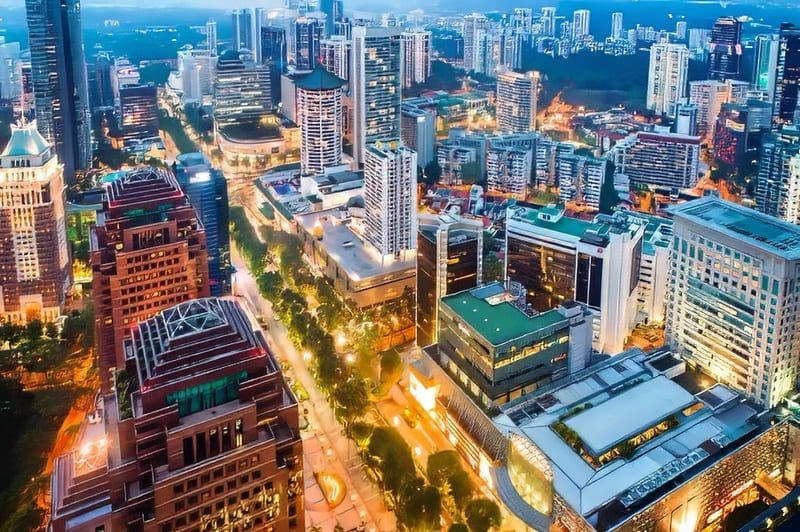 Skyline Singapore lúc chiều tối, các tòa nhà cao tầng nổi bật dưới ánh sáng vàng cam của bầu trời.