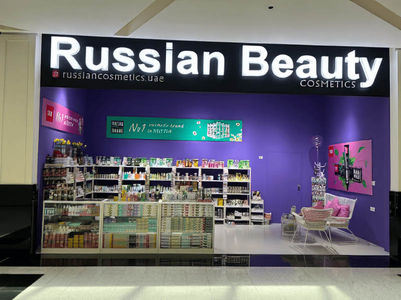 Cửa hàng mỹ phẩm "Russian Beauty" sáng sủa với nội thất màu tím chủ đạo. Các kệ trưng bày nhiều sản phẩm làm đẹp khác nhau. Một khu vực ngồi nhỏ với những chiếc ghế trong suốt và đệm màu hồng càng làm tăng thêm vẻ quyến rũ.
