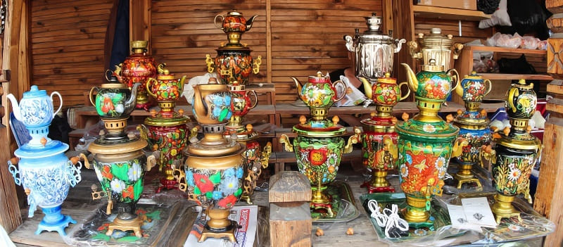 Ảnh minh họa: Một bộ sưu tập ấm đun nước samovar trang trí công phu, đầy màu sắc với họa tiết hoa văn tinh xảo được trưng bày trên các kệ gỗ, tạo nên một không gian sống động và mang đậm nét truyền thống.