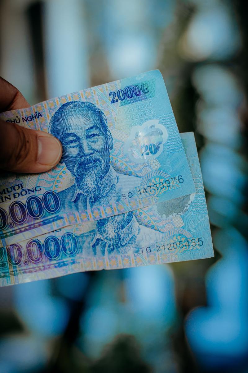 Tiền Việt Nam cầm trên tay minh họa lệ phí visa thanh toán bằng VND.